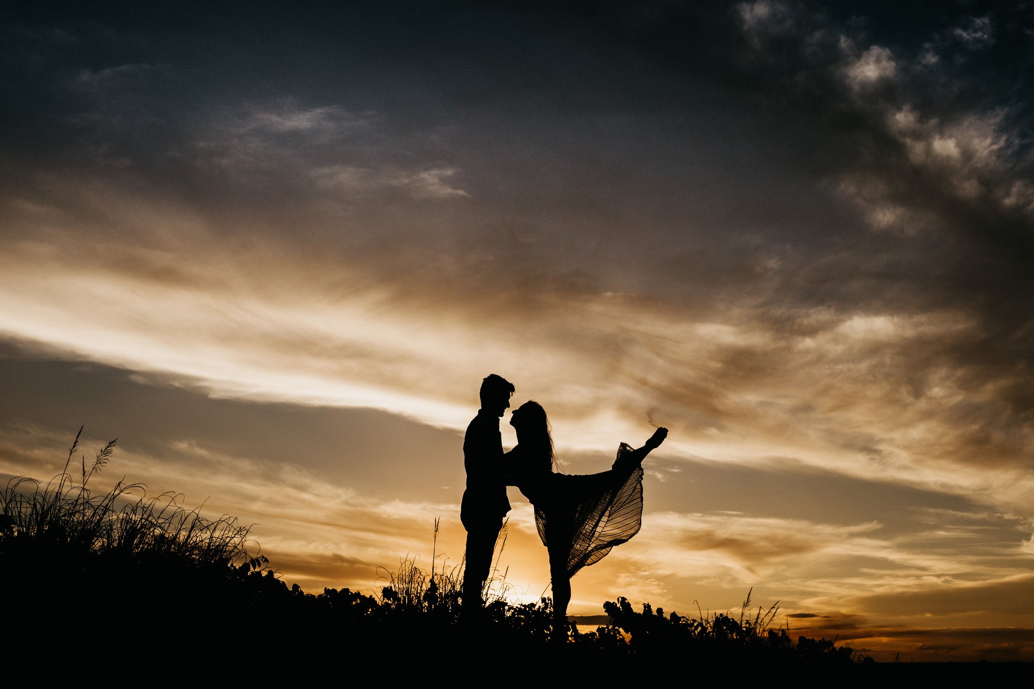 Unrecognizable woman with soulmate on grassy ground in twilight